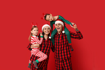 Happy family in Christmas pajamas on red background