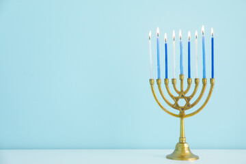 Menorah with burning candles on table in living room, closeup. Hanukkah celebration - obrazy, fototapety, plakaty