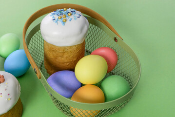 Easter cake and eggs in a basket. Green background.