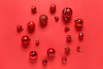Frame made of red Christmas balls on color background