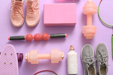 Different sports equipment and sneakers on lilac background