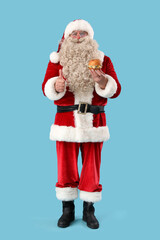 Santa Claus with tasty burger showing thumb-up on blue background