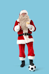 Santa Claus with soccer ball and french fries showing thumb-up on blue background