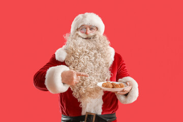 Santa Claus pointing at tasty falafel balls on red background