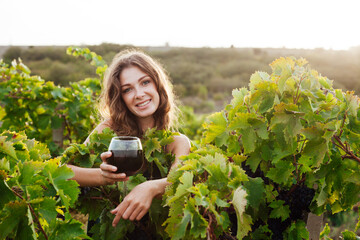 beautiful woman in a vineyard with a glass of wine