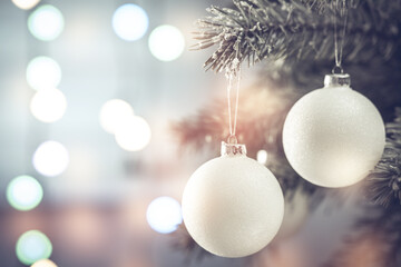 Christmas composition. Beautiful white balls on a Christmas tree branch close-up on a sparkling...