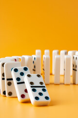 Row of domino tiles on yellow studio background