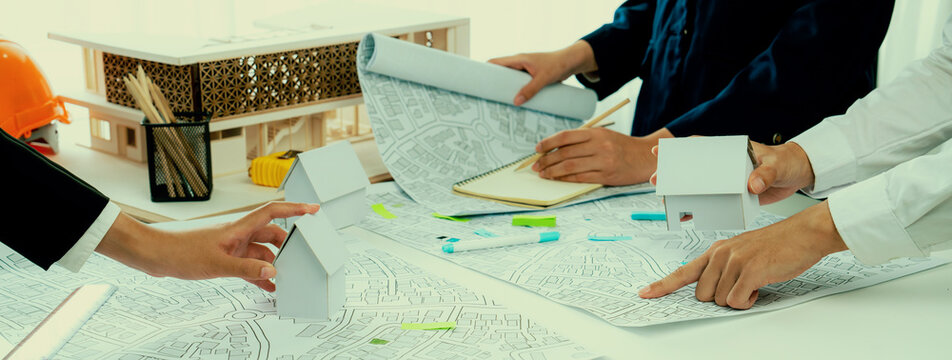 Worker, architect and engineer work on real estate construction project oratory planning with cartography and cadastral map of urban town area to guide to construction developer business plan of city