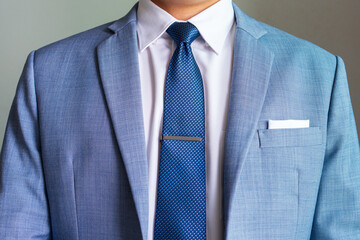 ฺBlue necktie in half winsor knot with single dimple and tie clip pairing with hidden button...