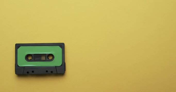 Video of retro tape with green label with copy space on yellow background