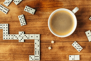 Domino game on brown wooden background close up