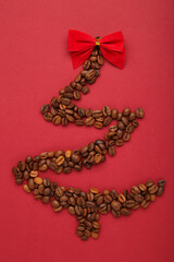 Christmas tree made from coffee beans on red background.