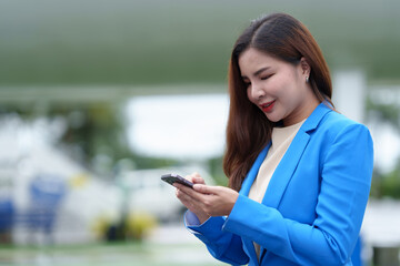 Business woman, traveler waiting for flight in airport, standing with luggage, using smartphone, traveling while waiting for flight Online internet search, flight check-in, travel ideas lifestyle.