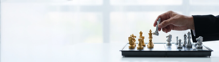 Businessman's hands move chess figures and checkmate opponent during match. Strategy, management, leadership, analysis of development for organizational success. copy space, banner, panorama