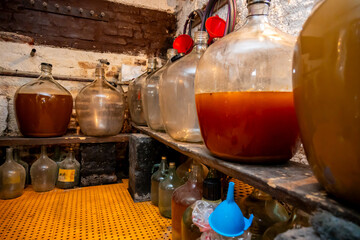 View of old fashioned wine cellar with glass storage for wine during fermentation process.