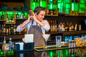Bartender using a shaker to mix ingredients of a cocktail