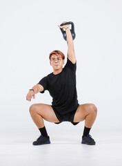 Obraz premium Portrait isolated cutout full body studio shot strong asian male fit athlete sportsman trainer model in casual sport workout outfit posing lifting kettlebell training on white background.
