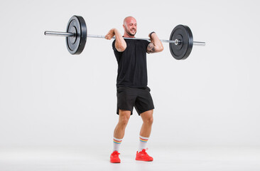 Fototapeta na wymiar Portrait isolated cutout full body studio shot strong Caucasian male fitness athlete sporstman trainer model in casual sport workout outfit posing lifting barbell training on white background.