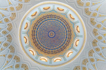 Painted gilded dome of Hazrati Imam mosque. Blue, gold and cyan concentric ornament with floral...