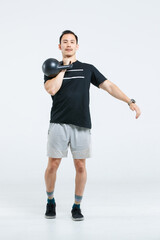 Isolated cutout full body studio shot of strong Asian male fitness athlete sportsman trainer model in casual sport workout outfit lifting kettlebell training exercising stretching on white background