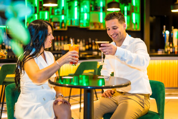 Happy couple toasting sitting on a luxury bar