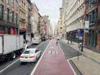 Fototapeta na wymiar rain drops on car window over traffic and street in New York, USA
