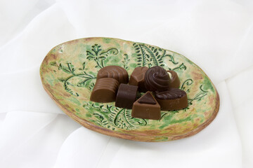 a lot of variety chocolate pralines on a clay plate