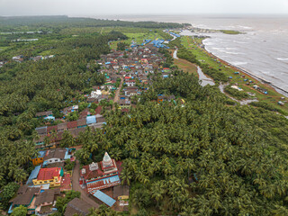 View of Alibag  Village in monsoon season at Konkan, Maharashtra, India. Traditional Indian village house surrounded by green grass and beautiful cloudy blue sky. Village landscape.