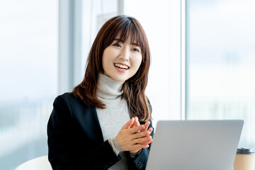 パソコンを使いながら話すビジネスウーマン