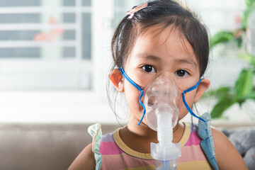 Kid girl making makes inhalation nebulizer steam sick cough at home, Asian Child using nebulizer mask equipment alone have smoke, stuffy nose and runny, oxygen spray inhaler therapy, Health medical - obrazy, fototapety, plakaty