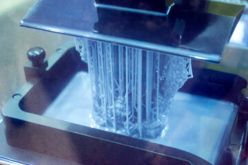 Working of photopolymer sla 3D printer. Platform with building object lowered into liquid...