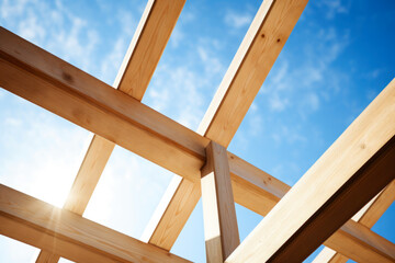 Wooden beams frame against a blue sky. The concept is construction progress.