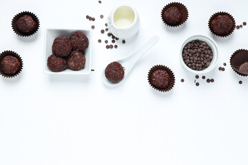 Brigadeiro and chocolate chips in bowls on white background, space for text