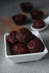 Brigadeiro on plate and spoon on gray background, close up