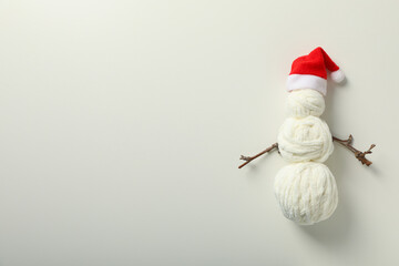 A decorative snowman made of balls of thread and a Santa hat