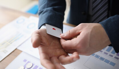 Close-up of businessman hands slightly showing hiding ace card under sleeve. Leadership and success...