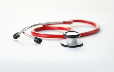Close-up of medical stethoscope with red cord on white background. Tool to check-up patients back and heartbeat. Healthcare medicine and illness concept