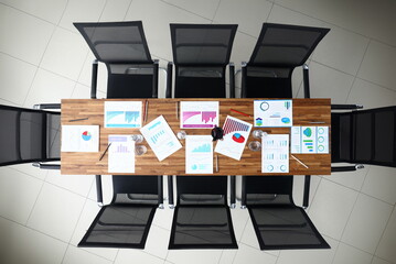 Paper with business chart on wooden table empty meeting room office closeup background. Finansial webinar concept. Site header mockup