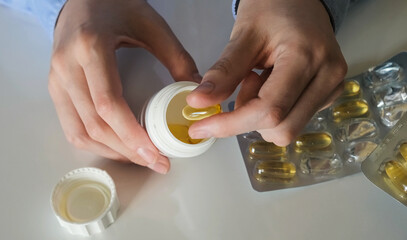 Putting Yellow Medical Pills in Jar. Medication concept