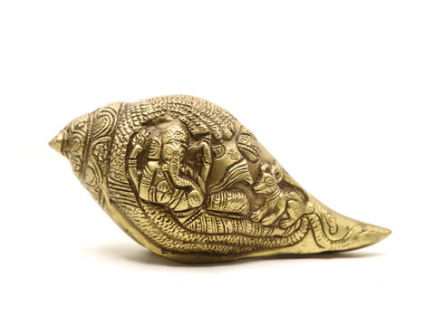 antique ganesha sculpture handcrafted with details on a religious conch shell made of brass used in temple and religious rituals isolated