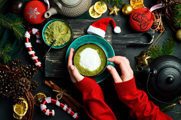 Matcha. Cup of Japanese matcha latte in female hands. Top view. Christmas and New Year decor.