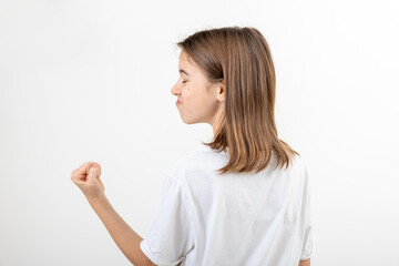 Fototapeta premium Teenager girl shows fist on white background isolated, side view.