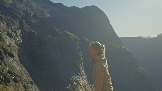 Woman walking away from blissful view during hike in New Zealand, Gertrude