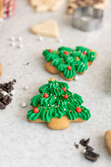Gingerbread cookies in the shape of Christmas trees on the kitchen table.