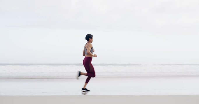 Fitness, running and woman on beach for race, competition or marathon training. Sports, warm up and young female athlete runner with cardio workout or exercise for health on the sand by ocean or sea.