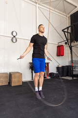 Fototapeta na wymiar Man jumping on skipping rope in the gym