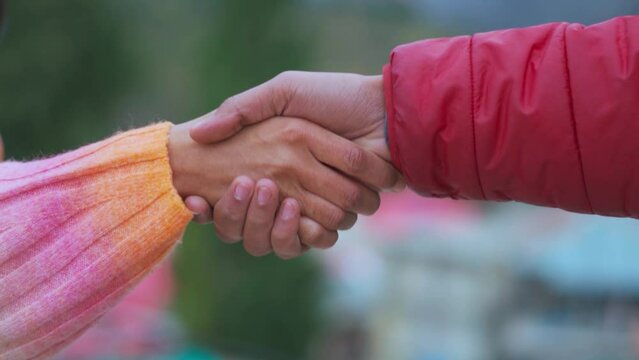 close up of two people shaking hands. Man and woman shaking hands. Business people handshake for deal. Friendship  between man and woman. Unknown couple shaking hands outdoors.