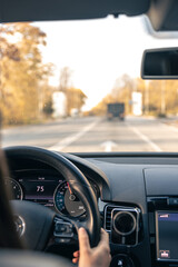 Woman driver hands on steering wheel inside car.