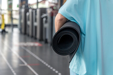 Woman holding yoga mat for fitness in gym, health or wellness workout.
