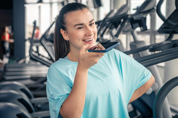 Athlete woman is talking to someone or recording voice message.